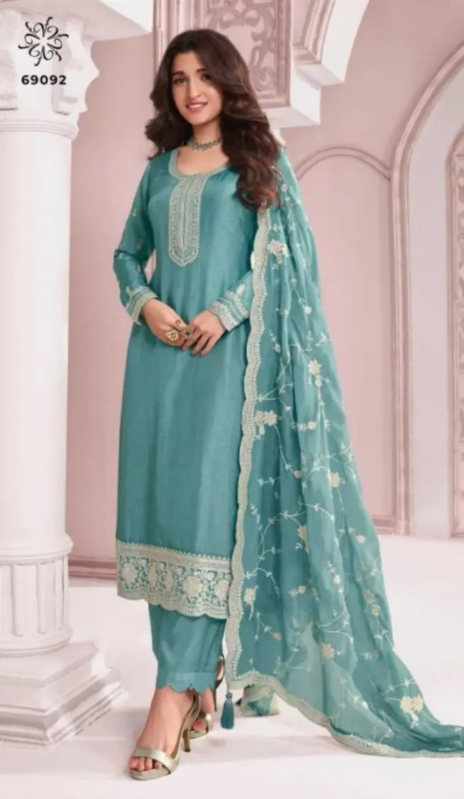 a girl stand x-pose and wear green colour suits